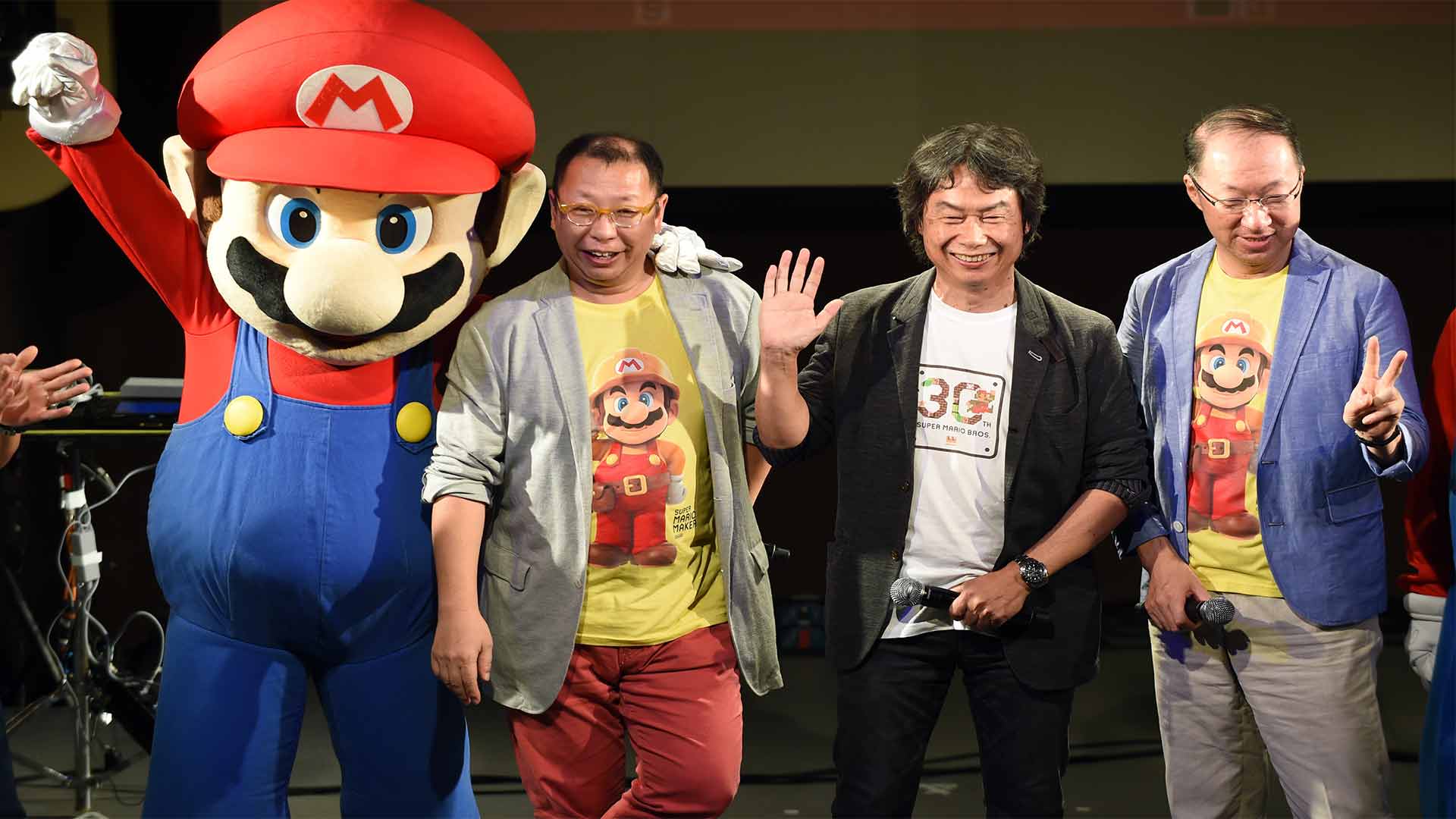 Takashi Tezuka, Shigeru Miyamoto und Koji Kondo auf Bühne mit Mario